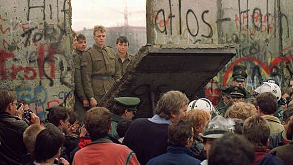 A crowd watches on November 11, 1989 as border guards demolish a piece of the Berlin Wall. A crowd watches on November 11, 1989 as border guards demolish a piece of the Berlin Wall.