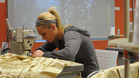 Project Runway contestant Althea at her sewing machine'
