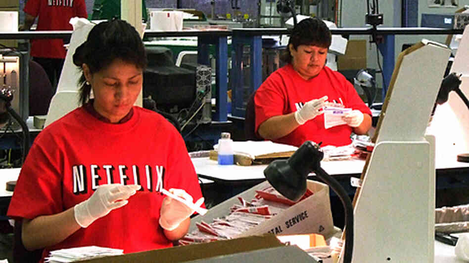 Workers sort DVDs at a Netflix distribution center. Workers sort DVDs at a Netflix distribution center.