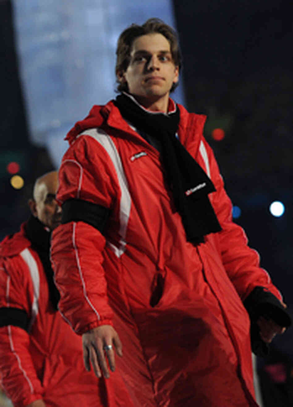 A member of Georgia's Olympic delegation marches in the opening ceremonies in a black scarf and armb A member of Georgia's Olympic delegation marches in the opening ceremonies in a black scarf and armb