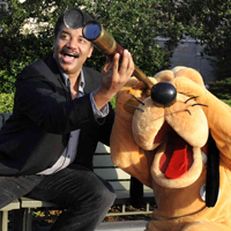 Neil deGrasse Tyson helps Pluto look through a telescope. Neil deGrasse Tyson helps Pluto look through a telescope.