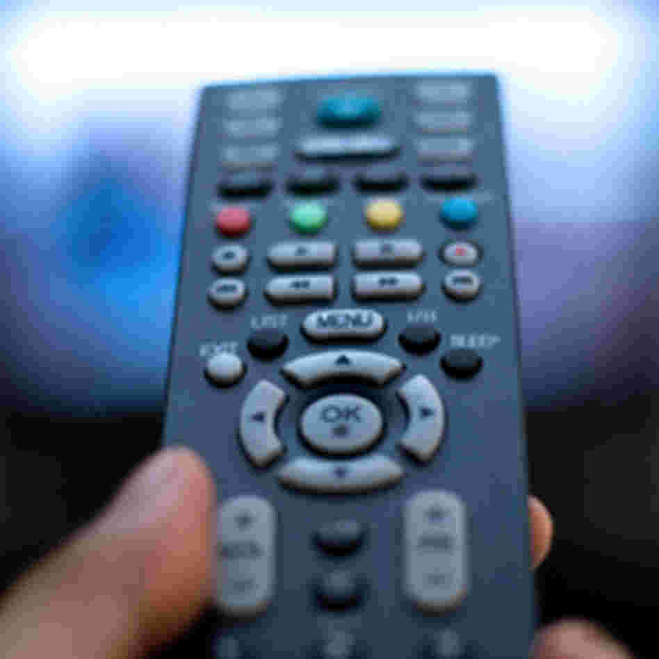 a thumb pressing a remote control. a thumb pressing a remote control.