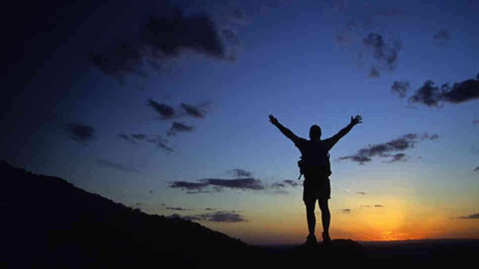 A man raises his arms to the sun. A man raises his arms to the sun.