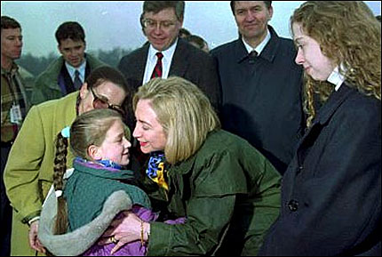 Then-first lady Hillary Clinton kisses a local child during her arrival at the Tuzla, Bosnia airport on March 25, 1996.