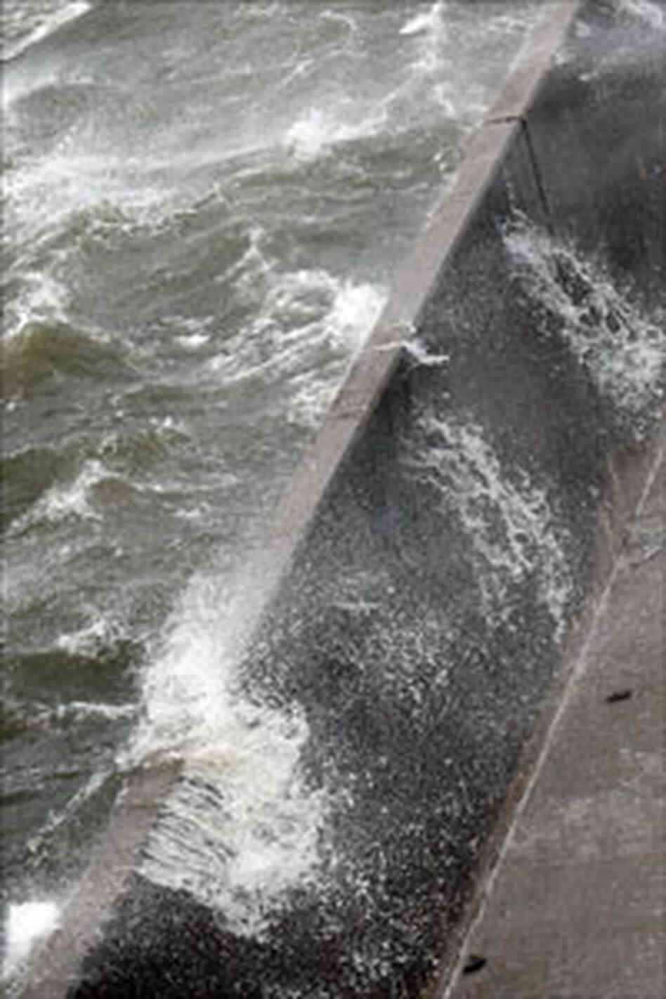 Water spills over the top of a levee on the Industrial Canal in New Orleans. Water spills over the top of a levee on the Industrial Canal in New Orleans.
