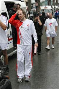 Former French tennis player Arnaud Di Pasquale reacts as he carries the extinguished Beijing Olympics torch in Paris on his way to place it in a bus for safety amid pro-Tibet protests. Patrick Kovarik/AFP/Getty Images