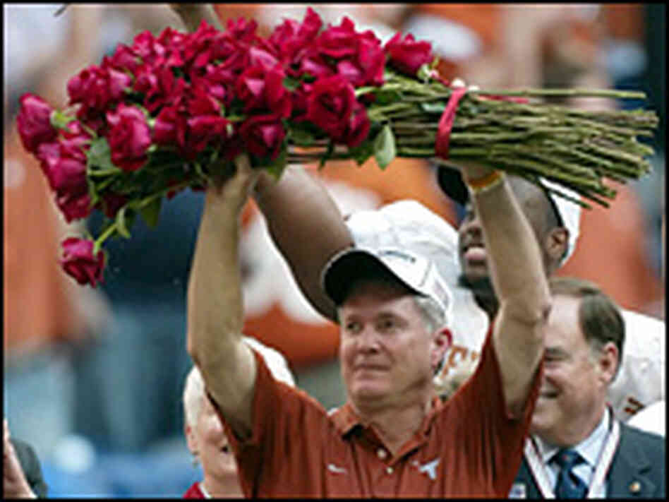 Longhorns coach Brown holds roses after Big 12 Championship victory. Longhorns coach Brown holds roses after Big 12 Championship victory.