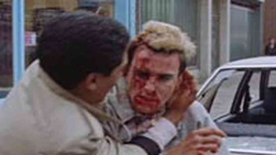 Omar protects Johnny from marauding skinheads outside their laundrette. Omar protects Johnny from marauding skinheads outside their laundrette.
