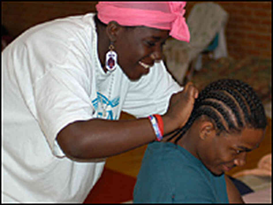 Joquita Stevens braids her brother Don's hair at a shelter in Austin.