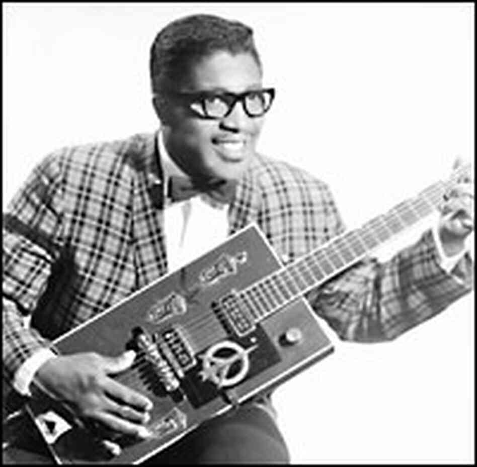 Bo Diddley pictured in the late 1950s, poses with his guitar.
