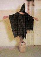 A hooded and wired Iraqi prisoner at Abu Ghraib prison.