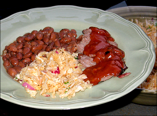 A Texas-inspired meal features slow-cooked beef brisket, beans and coleslaw.