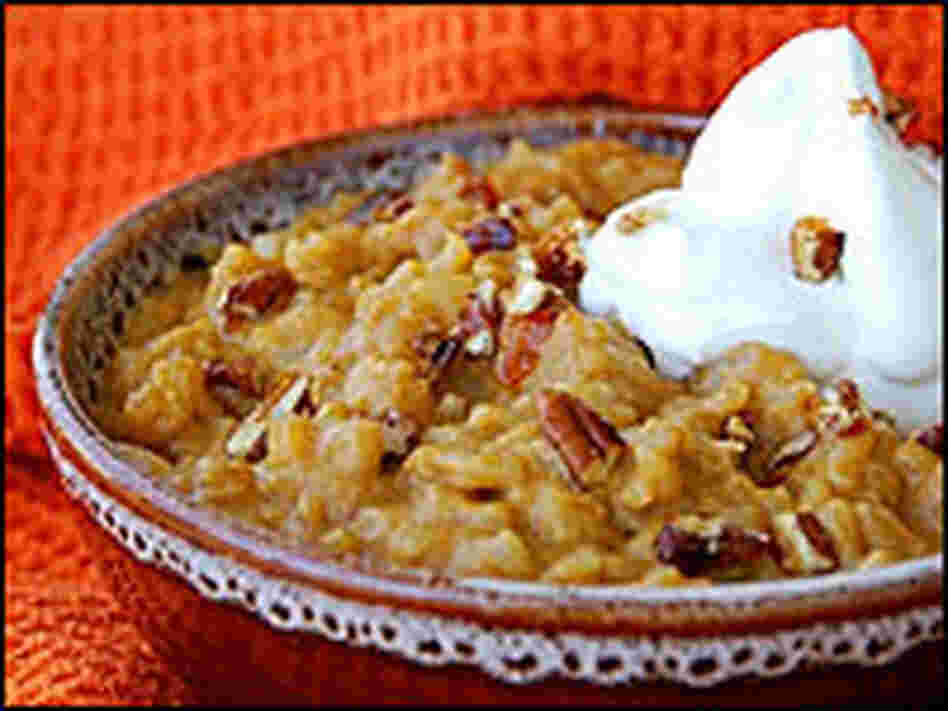 A bowl of 'Pumpkin Pie Risotto' topped with candied pecans and whipped cream