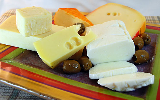 A platter of different cheeses and olives
