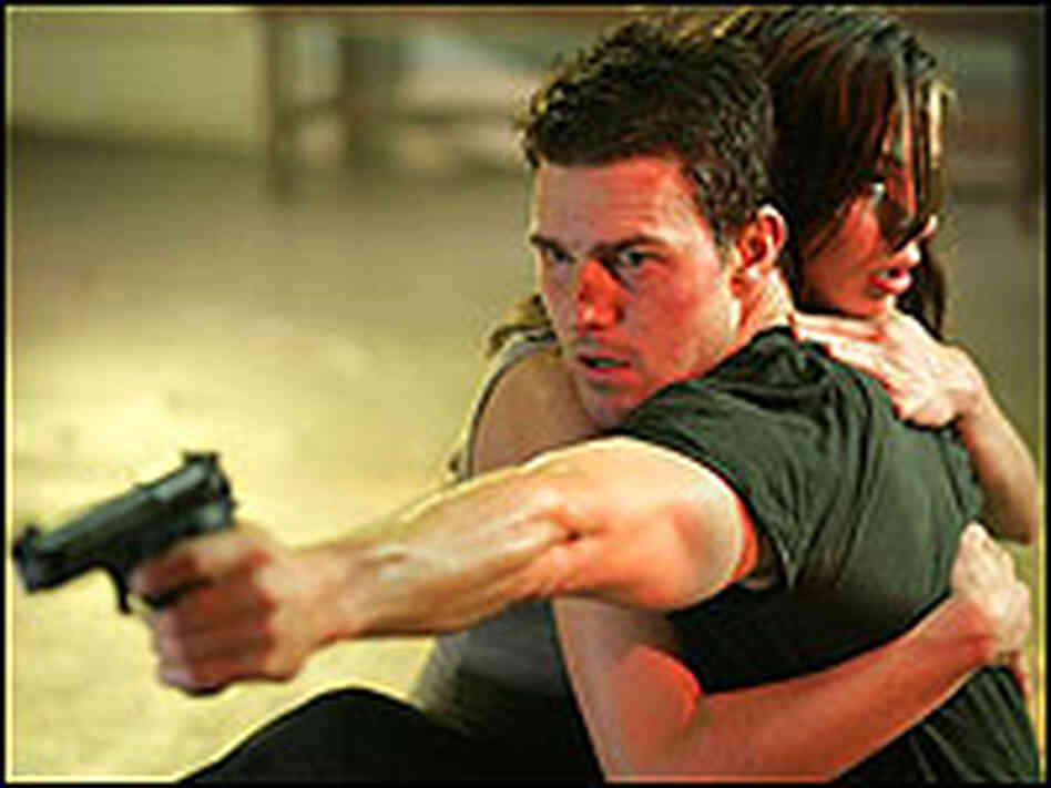 Tom Cruise points a gun as Michelle Monaghan clings to him in a scene from 'MI3' Tom Cruise points a gun as Michelle Monaghan clings to him in a scene from 'MI3'