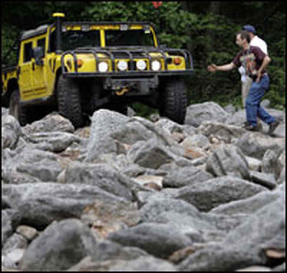 Two members of the Hummer Club try to direct a H1 Hummer inTremont, Pa..