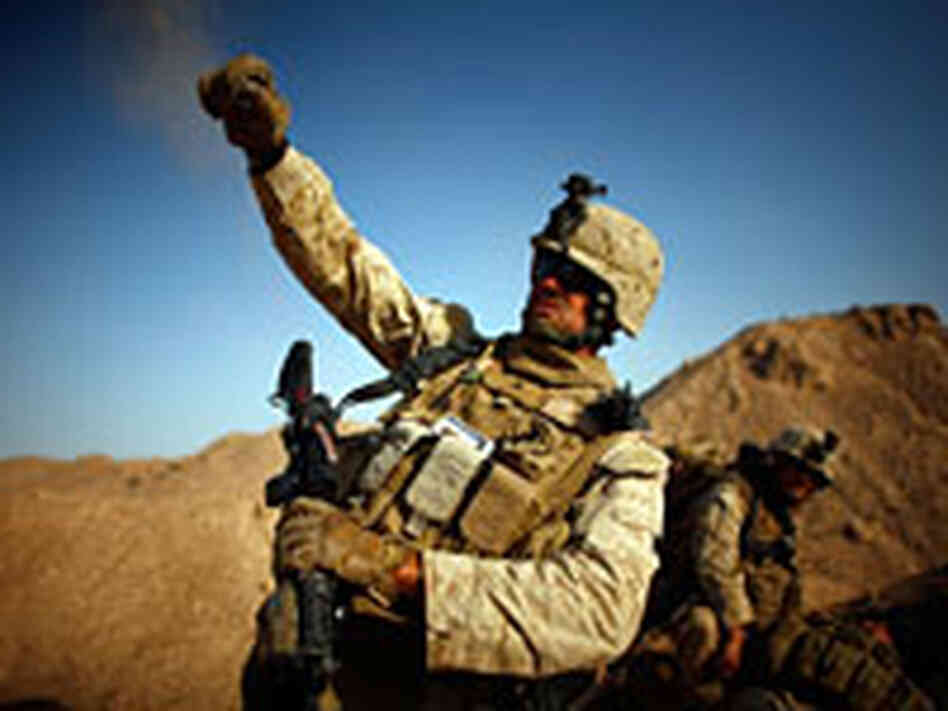 Cpl. Daniel Clift tosses a handful of rocks to simulate tossing a smoke grenade in Afghanistan.