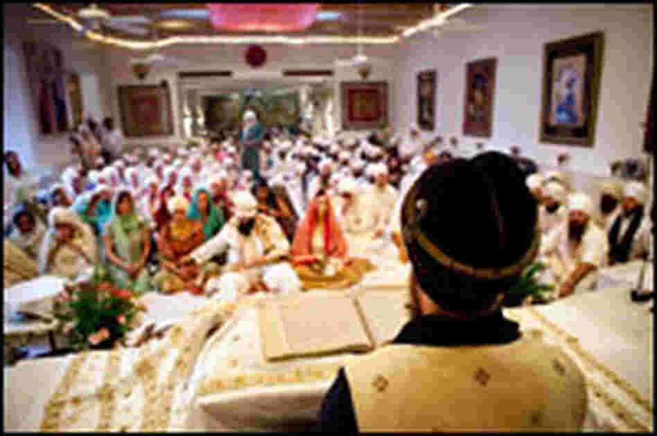 During a wedding ceremony, Sada Sat Sinran Singh reads from a book of sacred writings