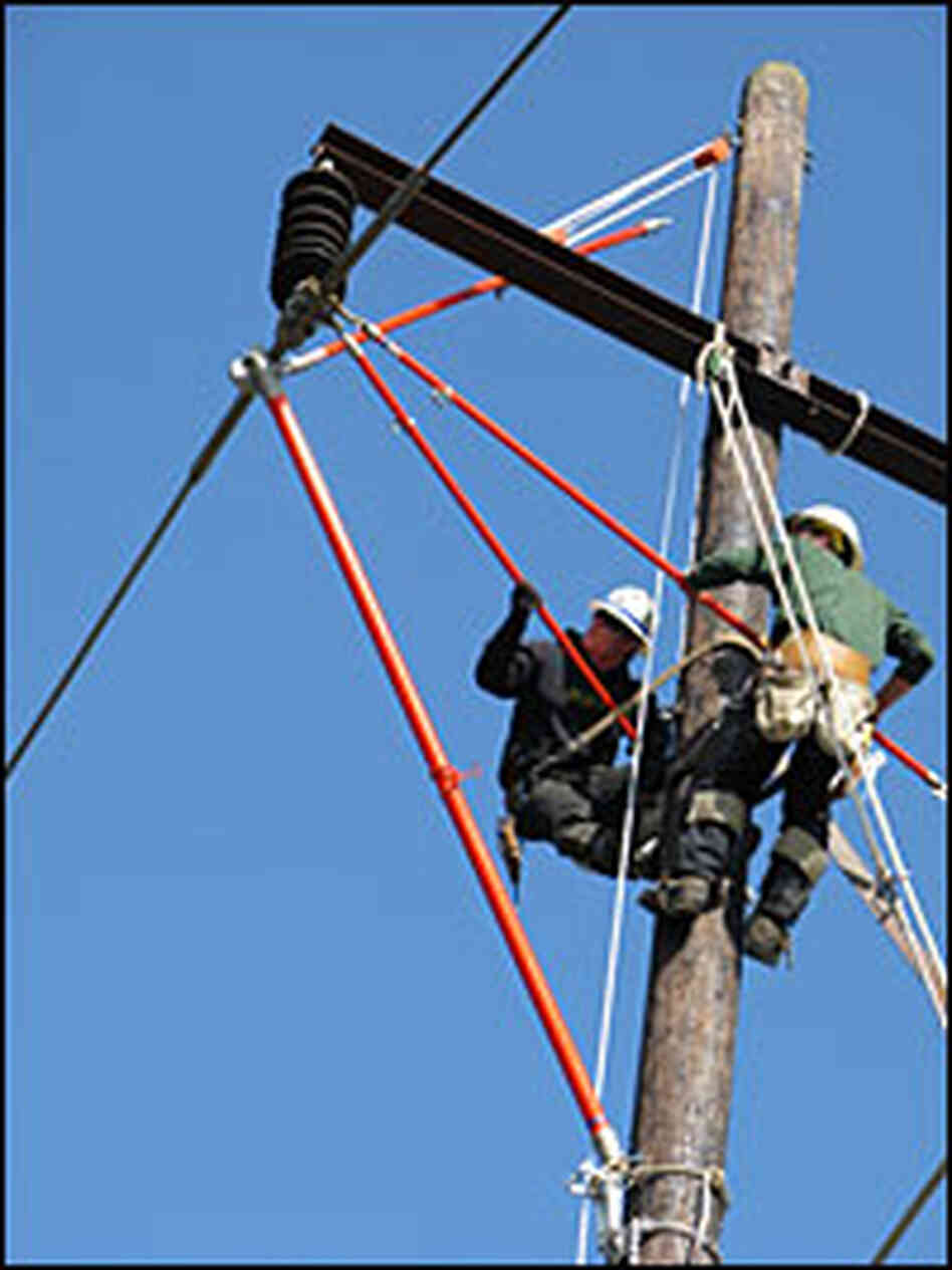 Workers practice repairing power lines.