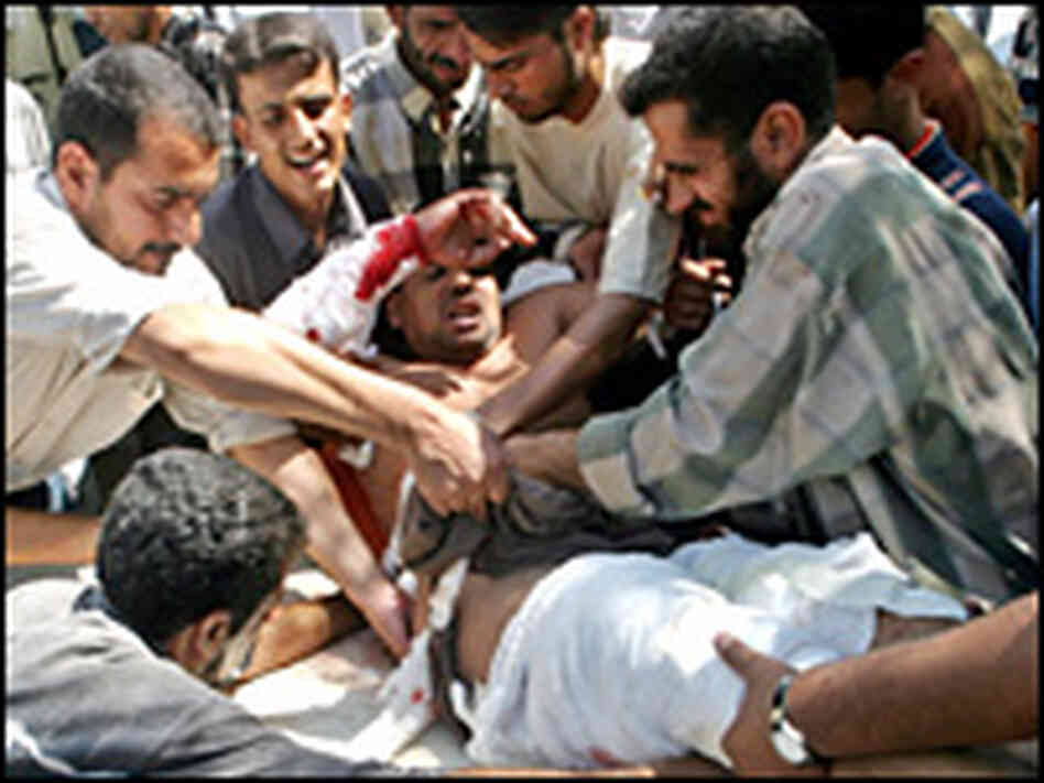 A wounded man is carried to a clinic after an attack on the main mosque in Kufa, Aug. 26, 2004. A wounded man is carried to a clinic after an attack on the main mosque in Kufa, Aug. 26, 2004.