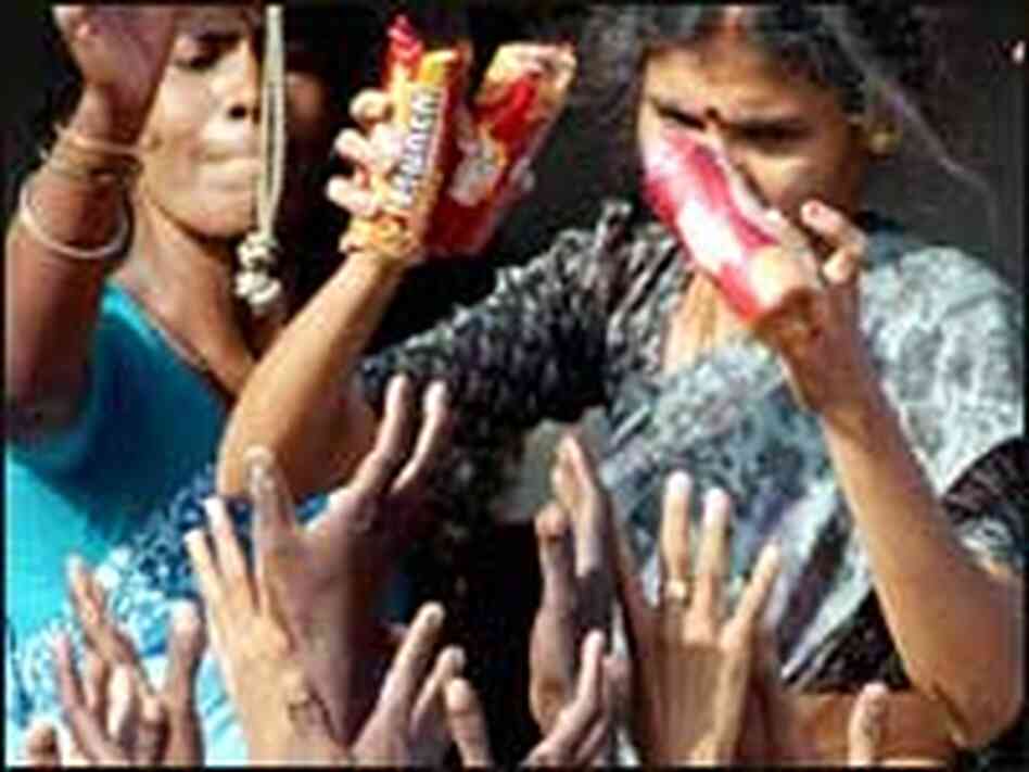 Tsunami survivors in Madras, India, reach for biscuits handed at a relief camp, Dec. 31, 2004. Tsunami survivors in Madras, India, reach for biscuits handed at a relief camp, Dec. 31, 2004.
