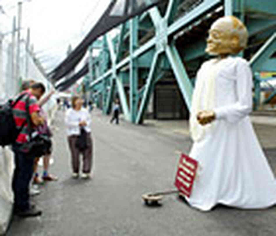 People discuss a large puppet of Mahatma Gandhi inside a designated area for protesting outside the People discuss a large puppet of Mahatma Gandhi inside a designated area for protesting outside the