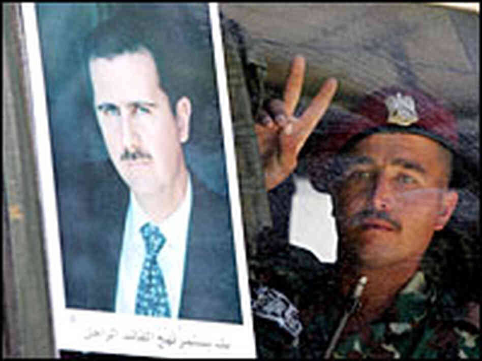 A Syrian army soldier flashes a victory sign behind a poster of Syrian President Bashar al-Assad A Syrian army soldier flashes a victory sign behind a poster of Syrian President Bashar al-Assad