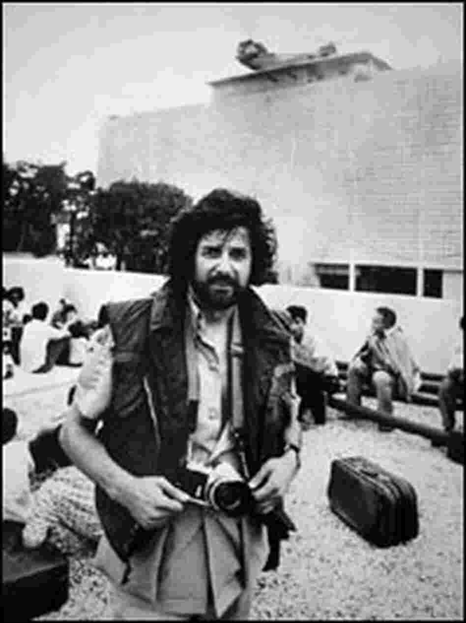 Loren Jenkins stands at the U.S. Embassy in Saigon as a helicopter takes off from the roof.