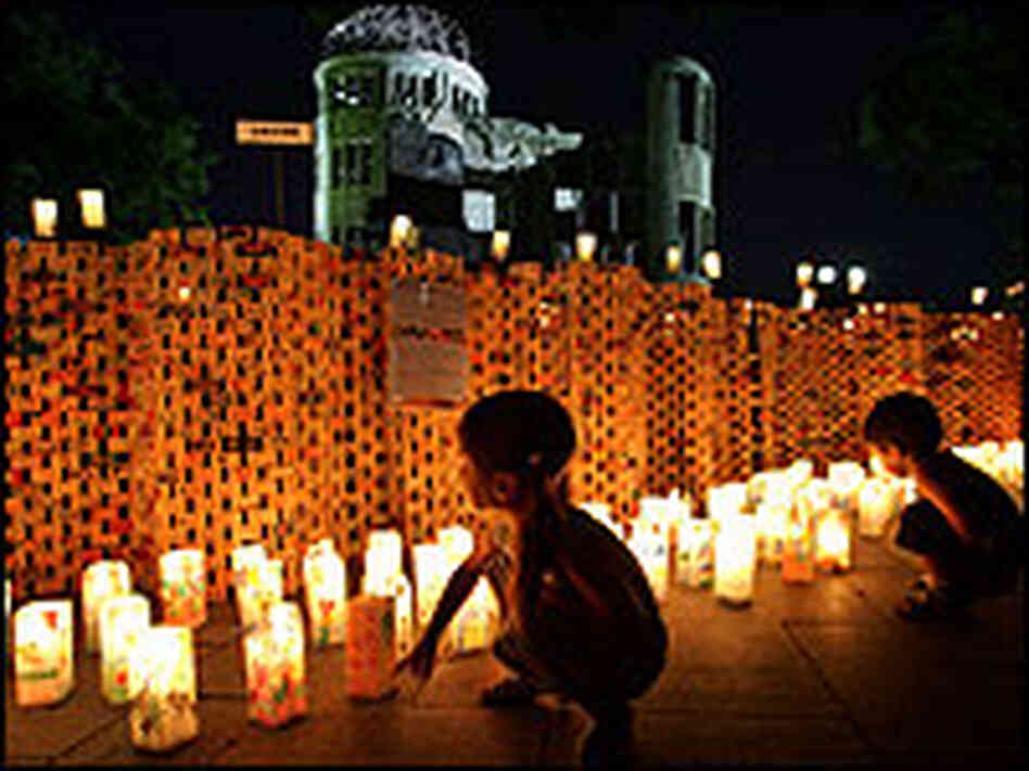 Children look at candles and messages placed around the A-bomb Dome. Children look at candles and messages placed around the A-bomb Dome.