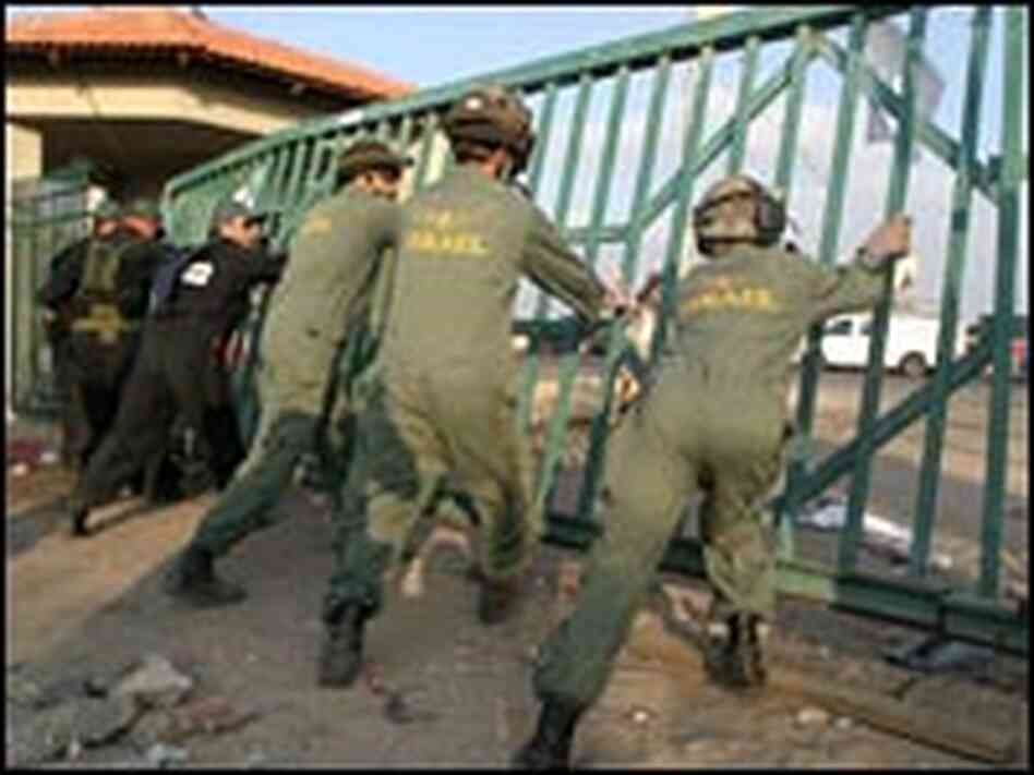 Israeli soldiers, police officers dismantle the main gate of the Jewish settlement of Neve Dekalim. Israeli soldiers, police officers dismantle the main gate of the Jewish settlement of Neve Dekalim.