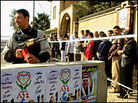 An Iraqi police commando guards a line of civilians waiting to cast their votes in Mosul An Iraqi police commando guards a line of civilians waiting to cast their votes in Mosul