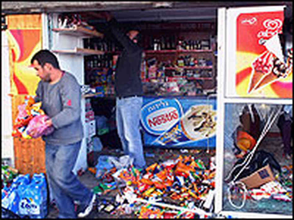 Shopkeepers sort through a ruined storefront in Tel Aviv. Shopkeepers sort through a ruined storefront in Tel Aviv.