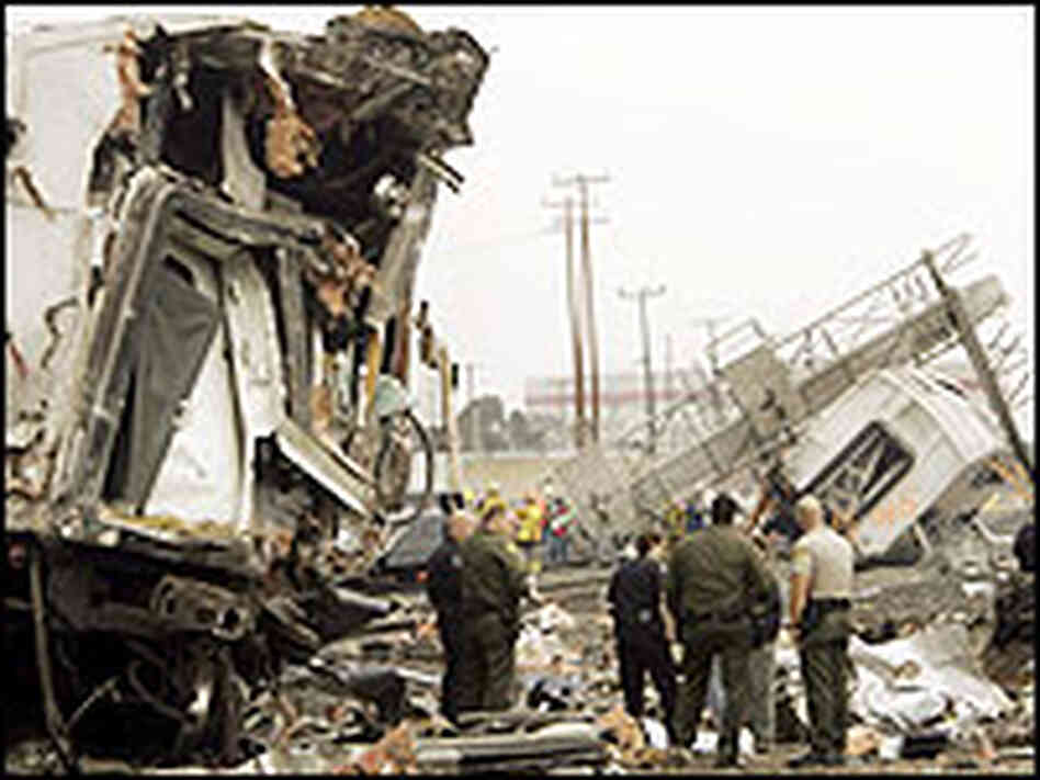 Investigators stand amid the wreckage of two commuter trains that collided Investigators stand amid the wreckage of two commuter trains that collided