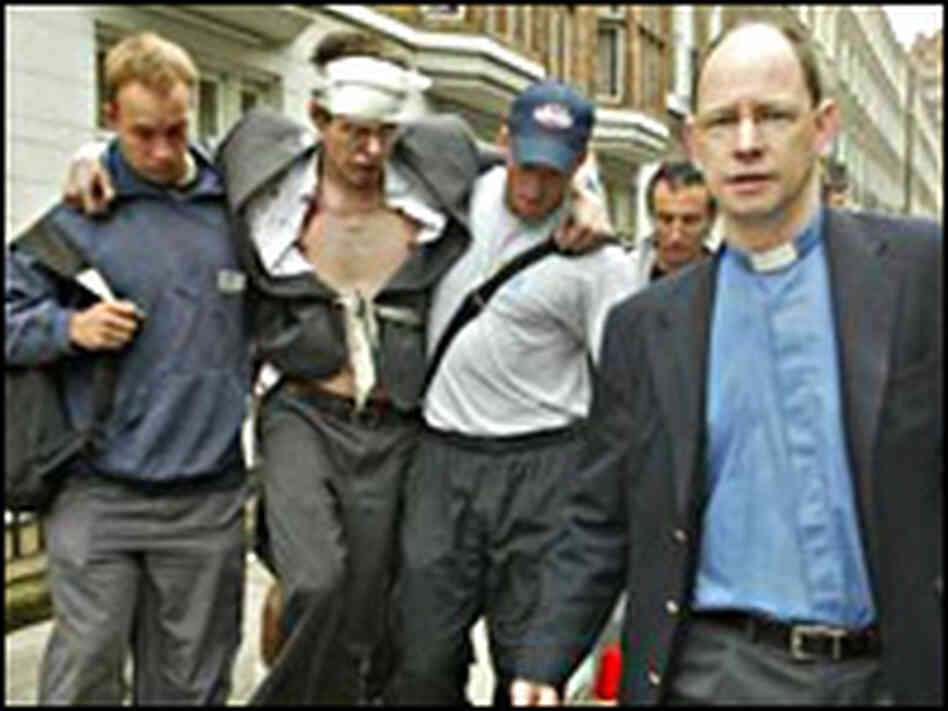 Rescuers help a man wounded near a London tube station in a series of attacks on the city's transi Rescuers help a man wounded near a London tube station in a series of attacks on the city's transi