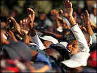 South Africans wave during a performance at the Africa Standing Tall against Poverty concert. South Africans wave during a performance at the Africa Standing Tall against Poverty concert.