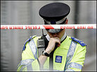 A police officer bows his head as he mans a security cordon. Photo: Reuters