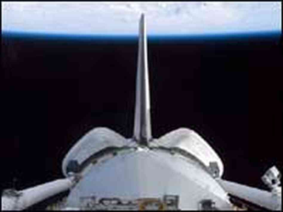 A view of Discovery's cargo bay over Earth's horizon. A view of Discovery's cargo bay over Earth's horizon.