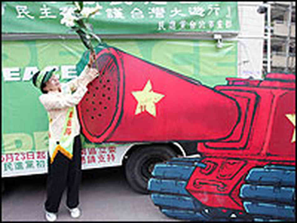 Taiwan Protester Places Flower on Cardboard Tank 