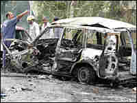 Iraqi men gather at the scene of a car bomb explosion in Baghdad Iraqi men gather at the scene of a car bomb explosion in Baghdad