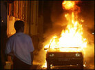 A resident looks at a burning car in Strasbourg, on the French-German border, Nov. 7, 2005