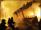 Firefighters spray water on a burning bus outside Toulouse Firefighters spray water on a burning bus outside Toulouse