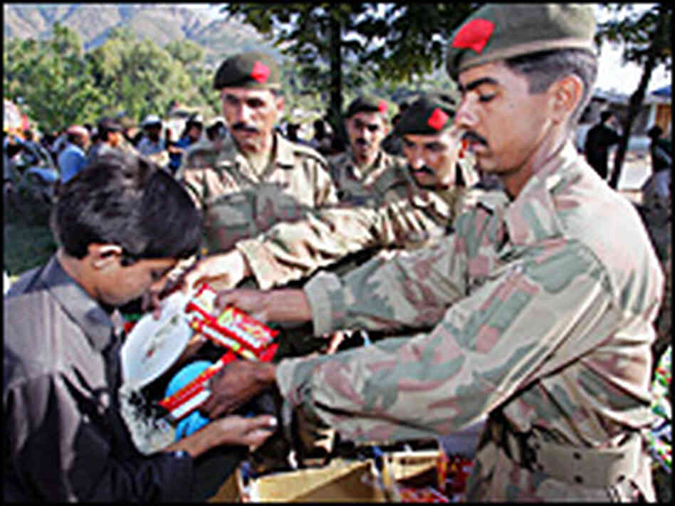 A victim of South Asia's earthquake receives goods from military personnel at Battal in Pakistan A victim of South Asia's earthquake receives goods from military personnel at Battal in Pakistan