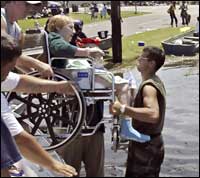 A patient of the United Medical Rehabilitation Hospital is unloaded from a boat.