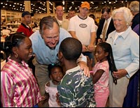 Former President George H.W. Bush and first lady Barbara Bush visit evacuee children during a tour of Reliant Hall adjacent to the Astrodome.