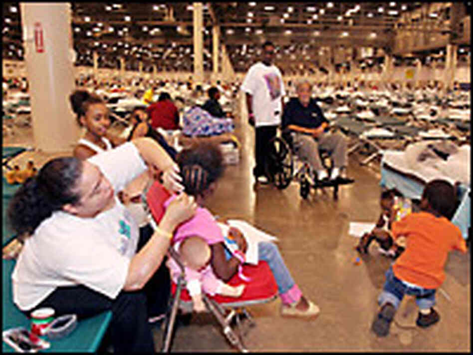 Volunteer Melissa Jackson braids the hair of evacuee Traviell Barra of New Orleans. Credit: Reuters.