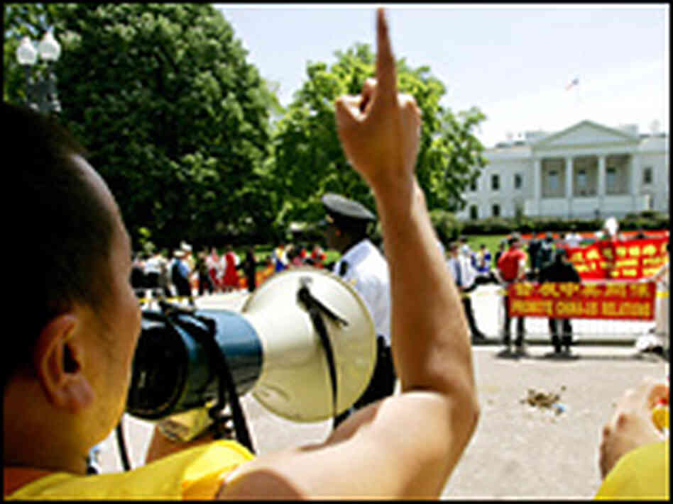 Potesters use a megaphone to address the the White House. Potesters use a megaphone to address the the White House.