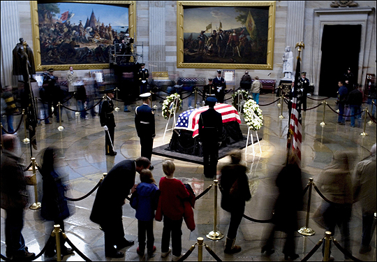 Visitors to the Capitol Rotunda pass by the flag-draped coffin of the 38th president.
