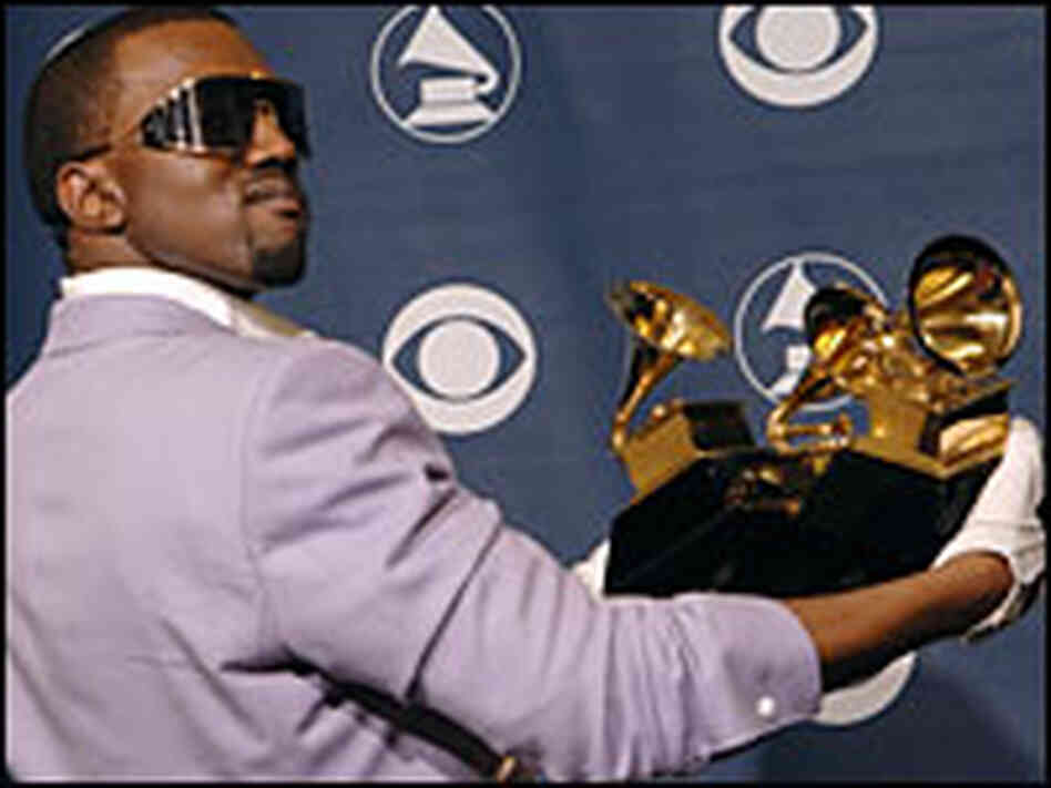 Kanye West holds an armful of Grammy awards. Kanye West holds an armful of Grammy awards.