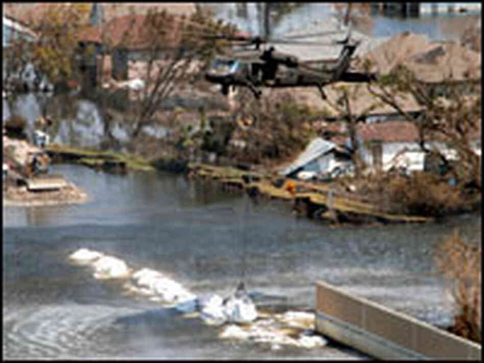 A Texas Army National Guard helicopter deposits a 6,000 pound-plus bag of sand and gravel  