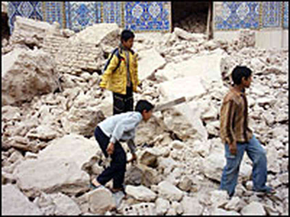Iraqi Shiites walk on the rubble of the damaged al-Hadi Shiite shrine Iraqi Shiites walk on the rubble of the damaged al-Hadi Shiite shrine